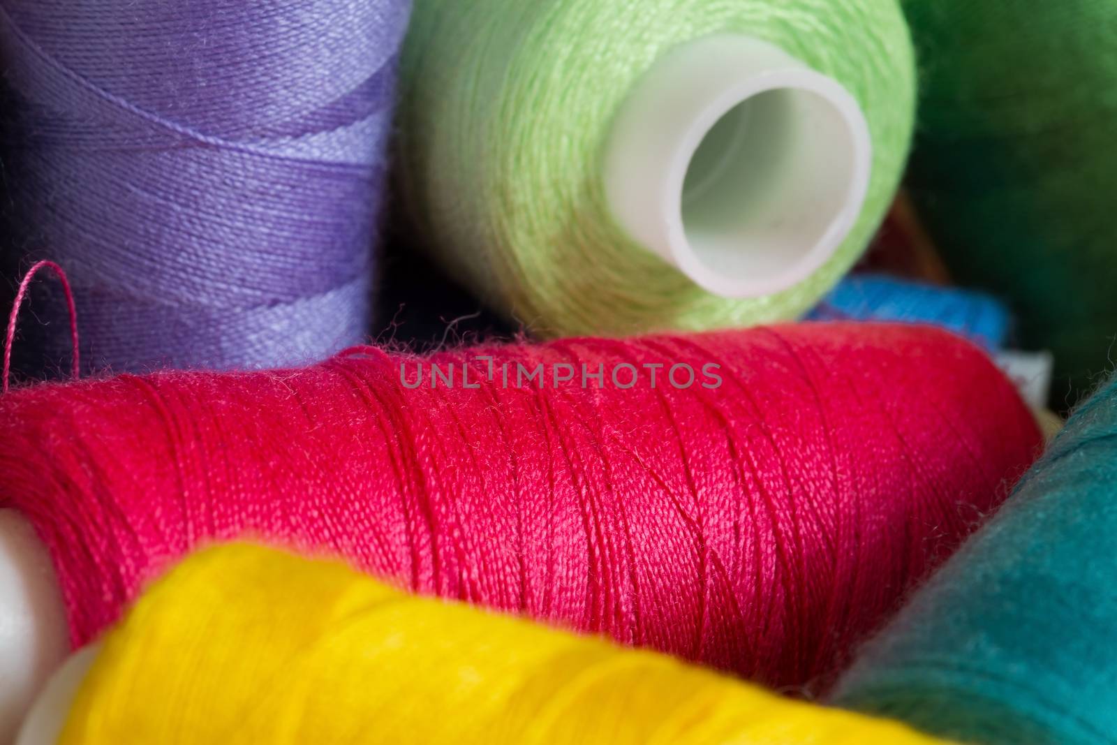 Pile of coloured bobbins of thread by fogen