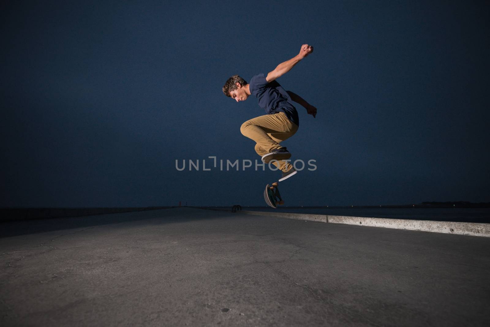 Skateboarder performing a ollie flip on a concrete pavement by homydesign