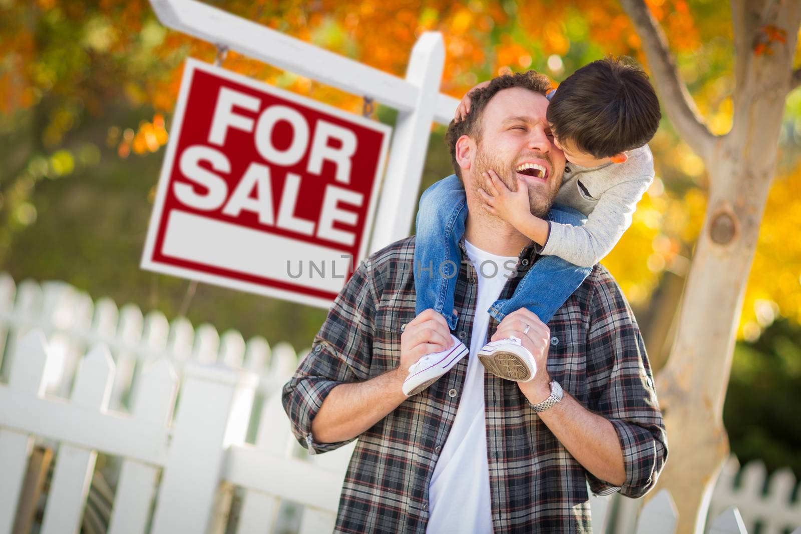 Young Mixed Race Chinese and Caucasian Father and Son In Front of For Sale Real Estate Sign and Fall Yard.