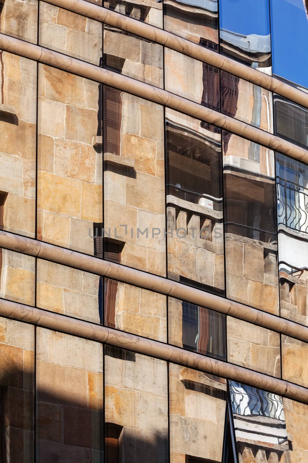 reflection of stone facade on modern glass facade