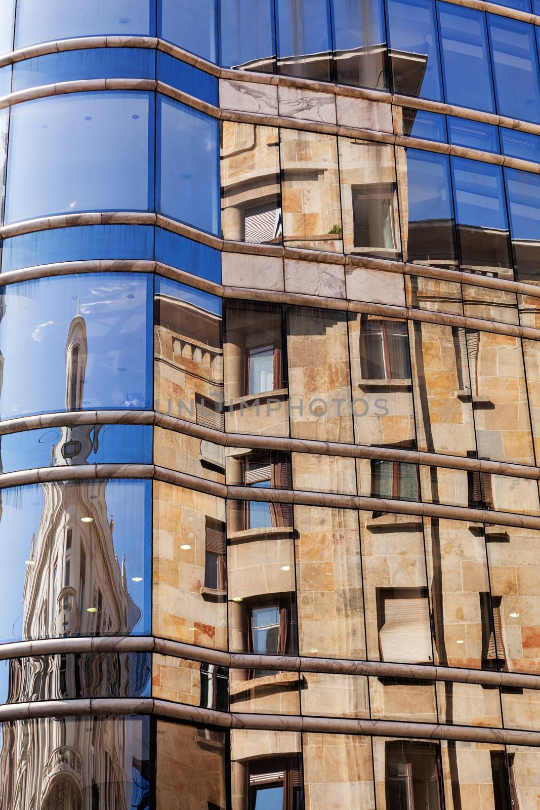 reflection of stone facade on modern glass facade