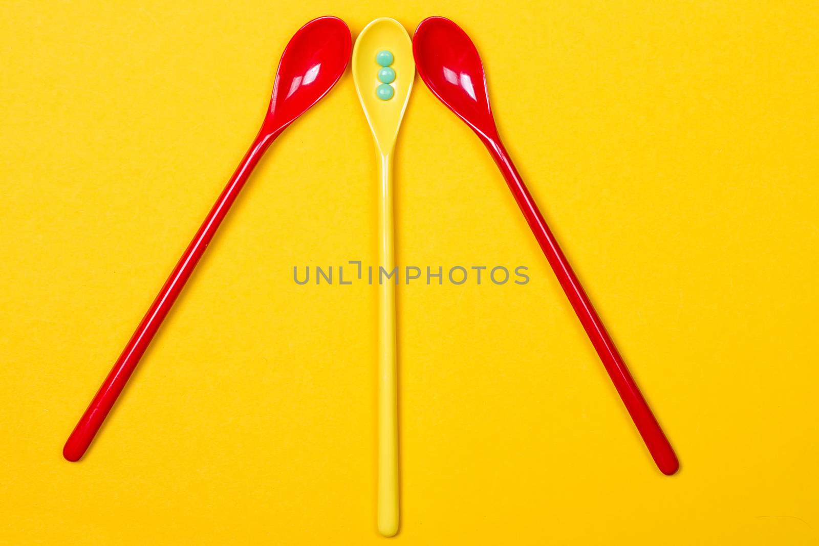 Spoonful of Pills to Keep Healthy Concept Image on yellow background