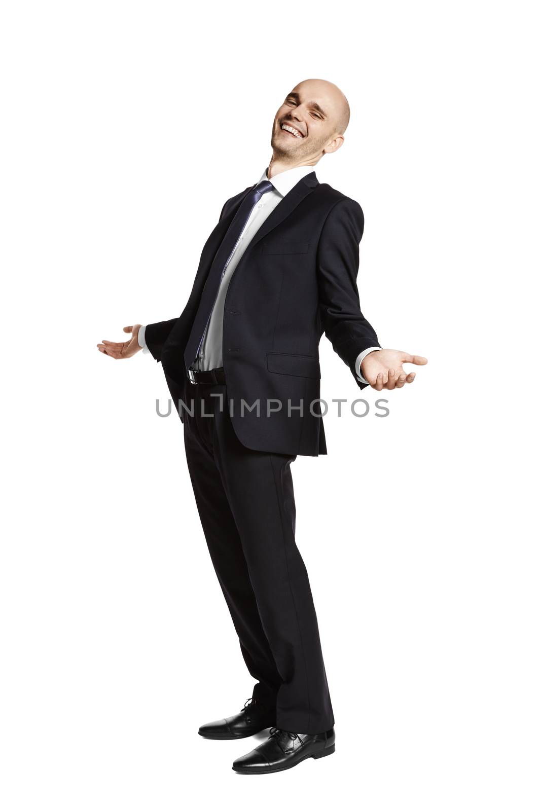 Side view of laughing young man in black suit on white background.