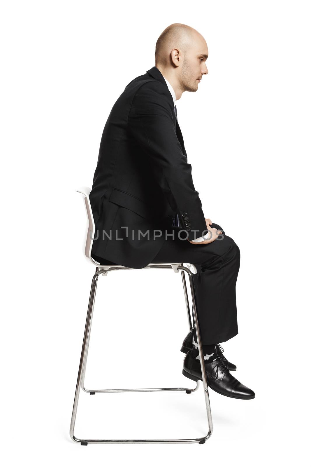 Profile view of young tired office worker sitting on a chair. Studio shot isolated on white background.