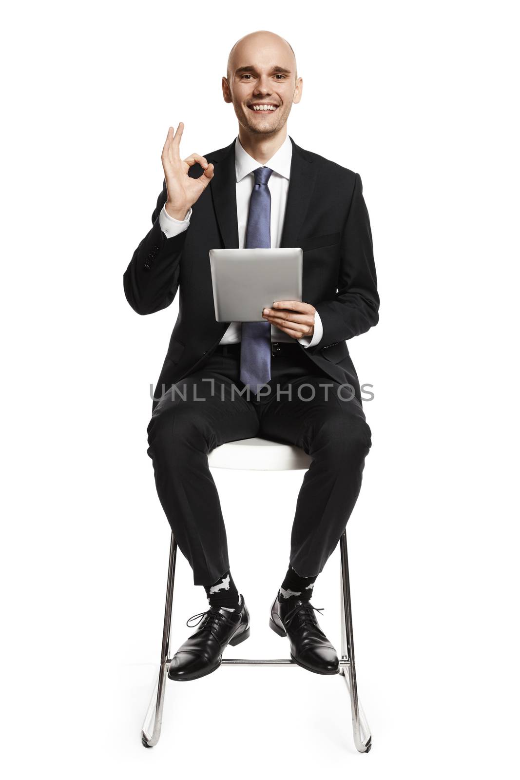 Cheerful young man working on digital tablet. Studio portrait isolated on white background.