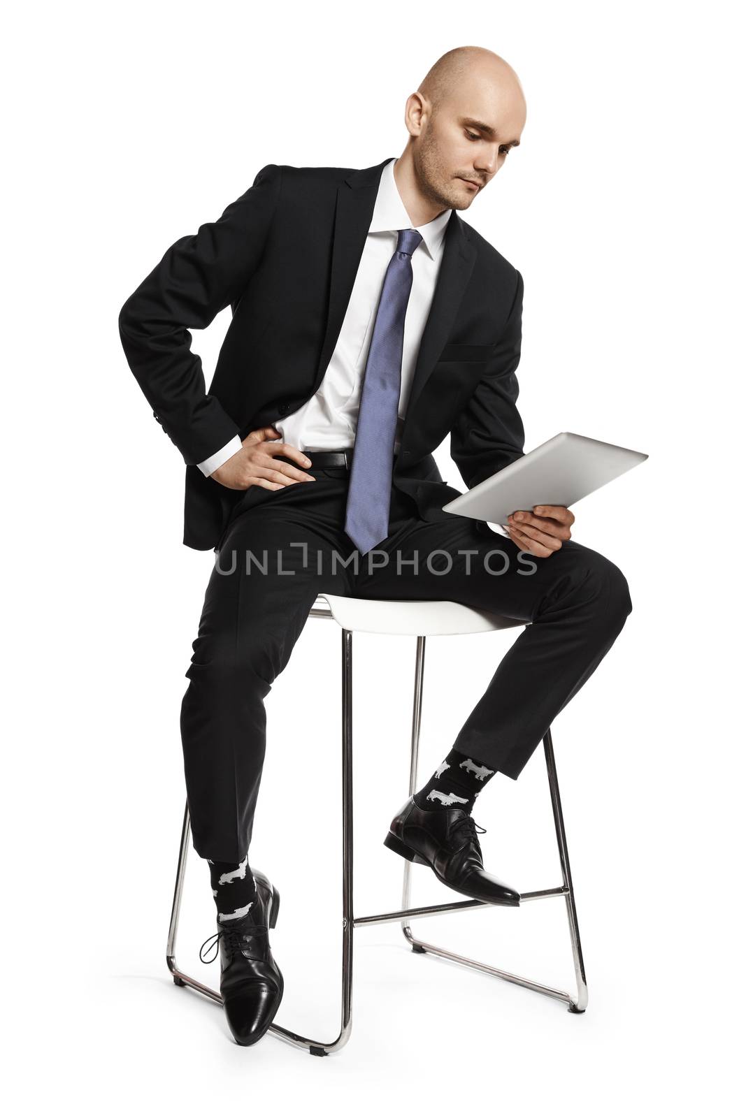 Concentrated man reading from tablet. Side view of young man isolated on white background.