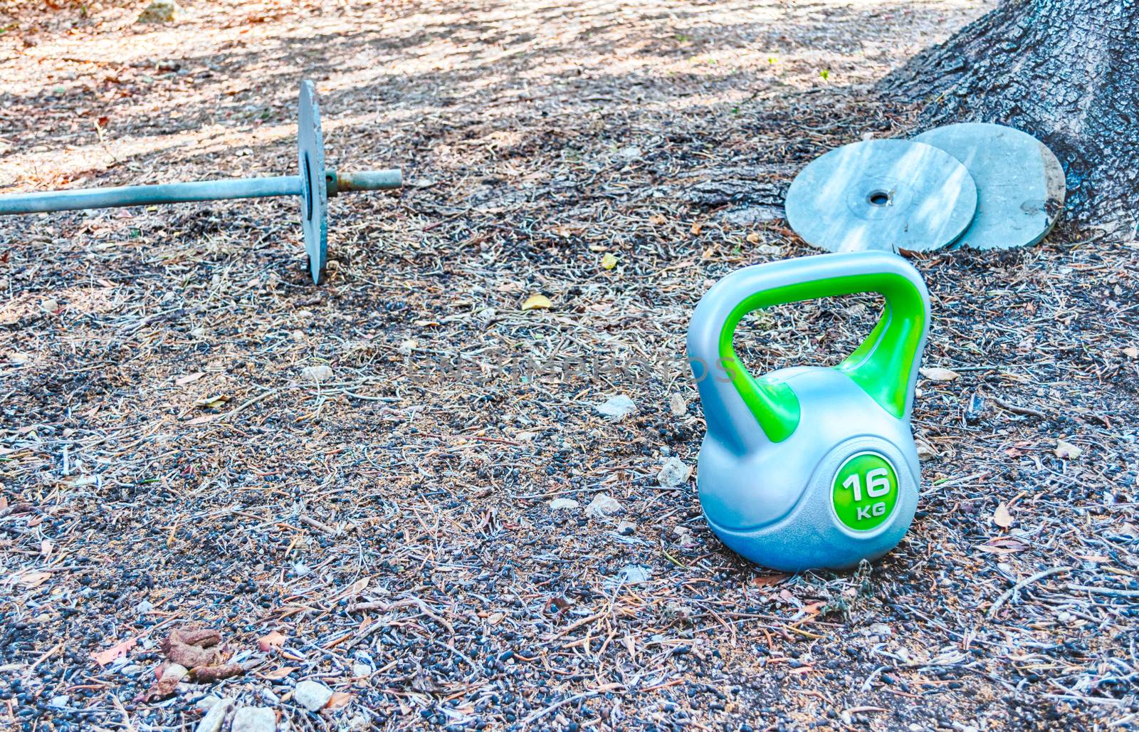 Homemade gym in a garden with barbell and ketttlebell