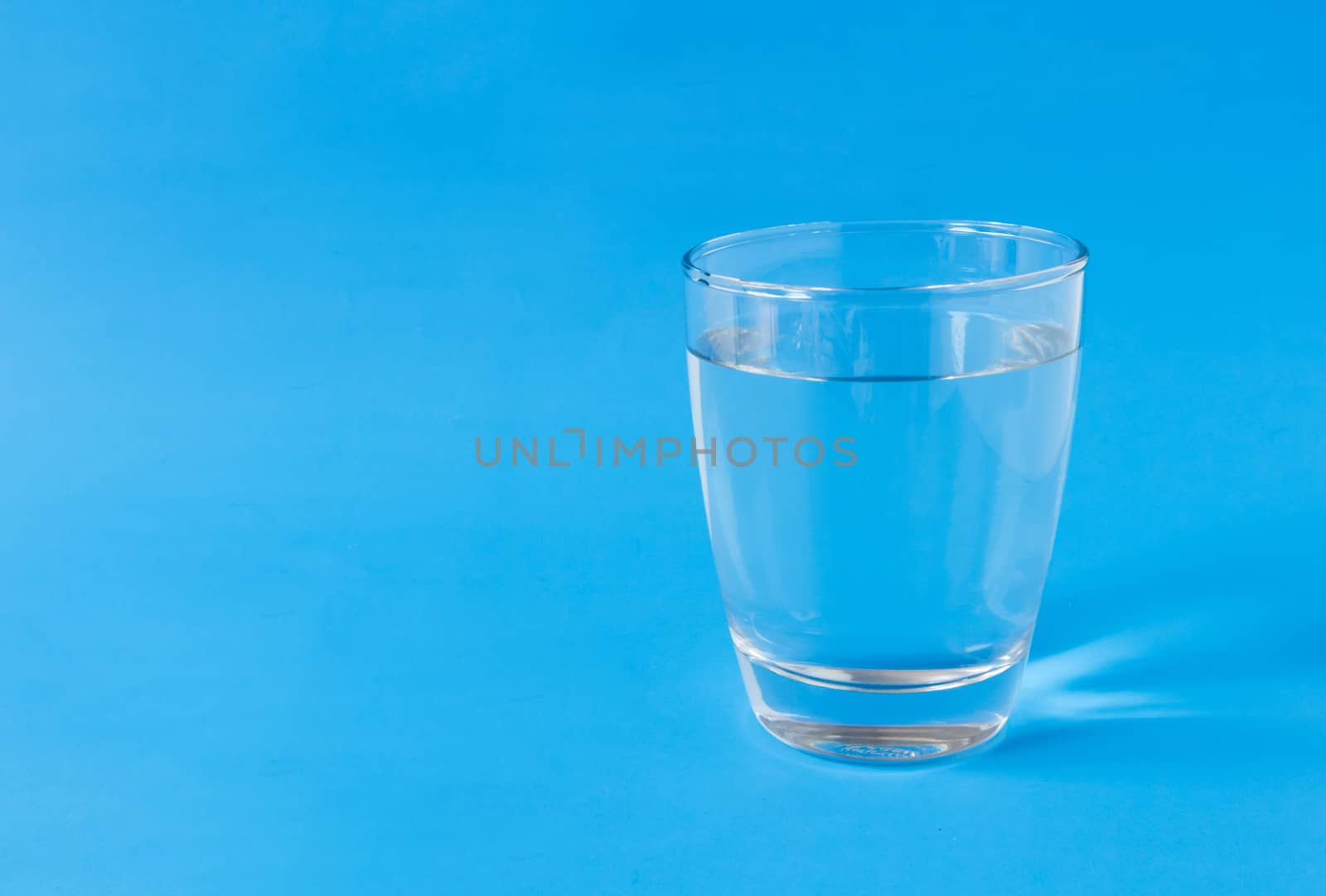 Water in glass on blue background