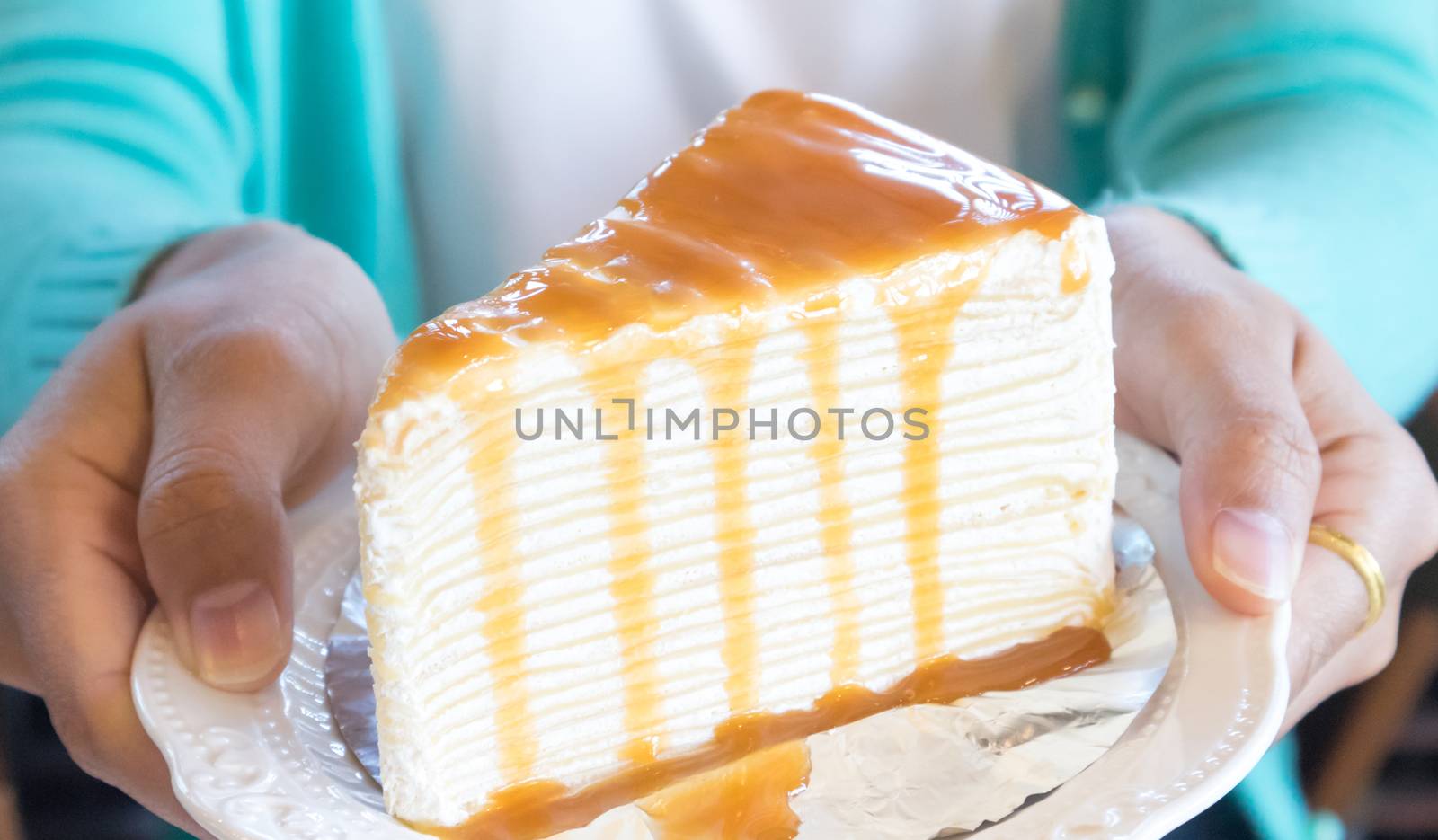 Closeup woman holding crape cake caramel, selective focus