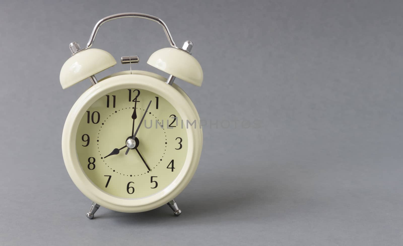 Retro alarm clock on grey background, time concept