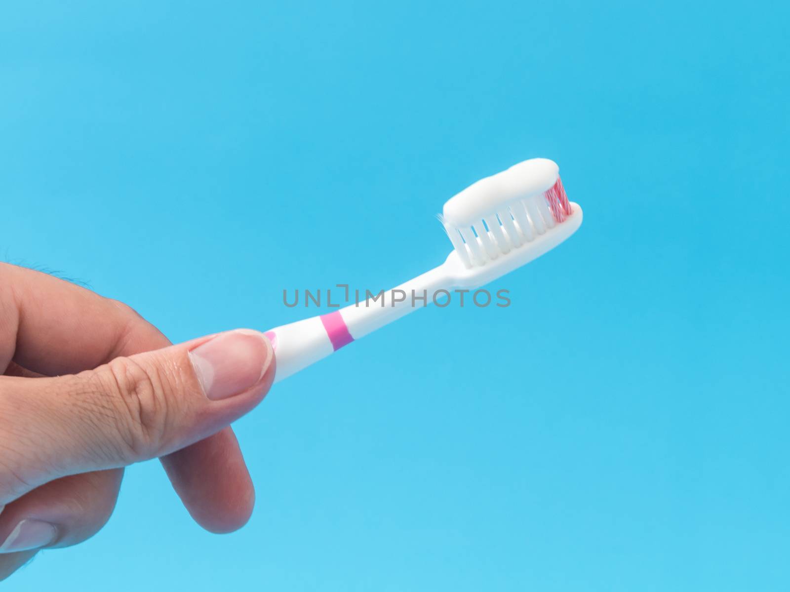 Closeup man hand holding toothbrush with blue background