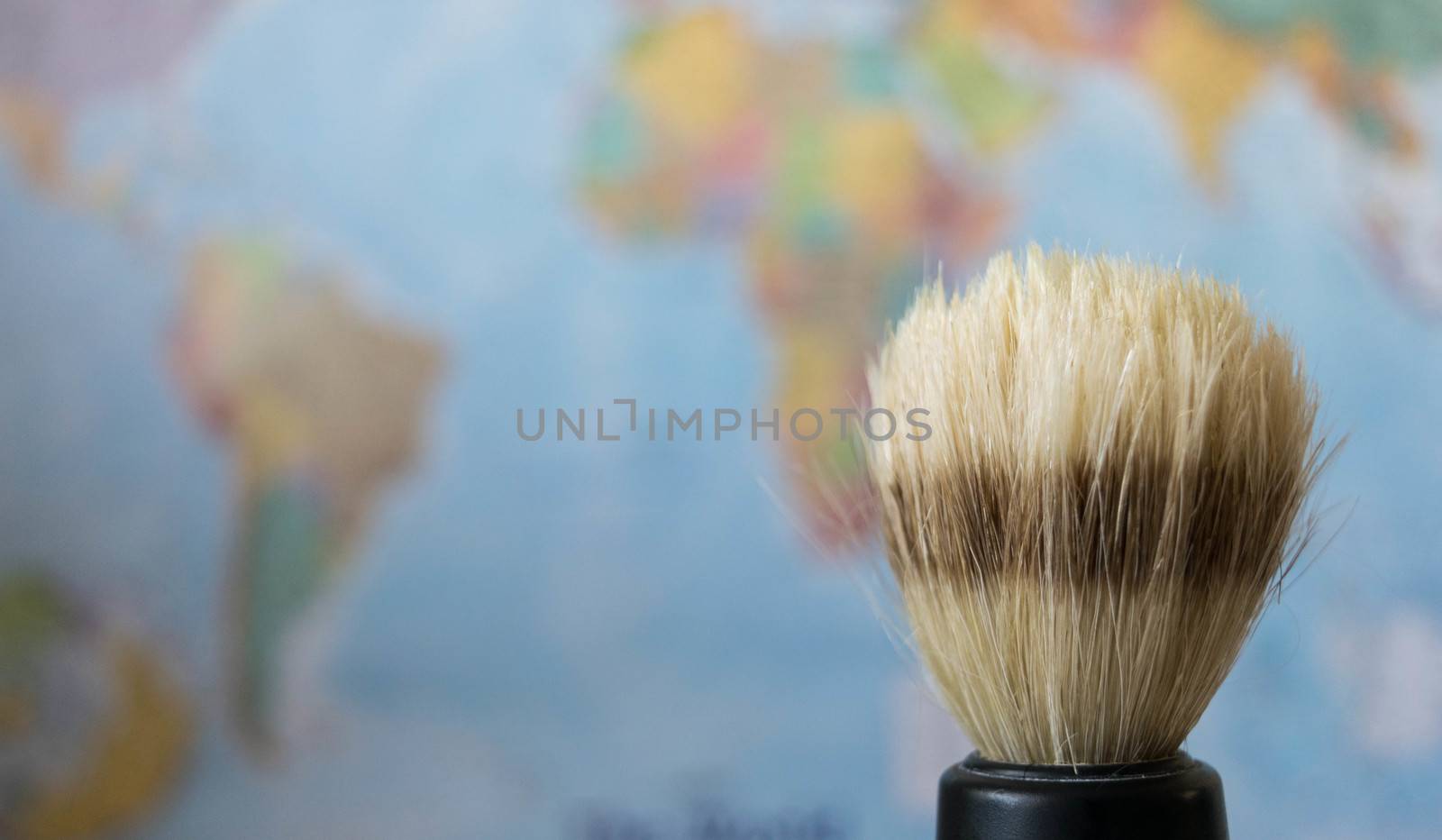 old style shaving brush on a world map background.