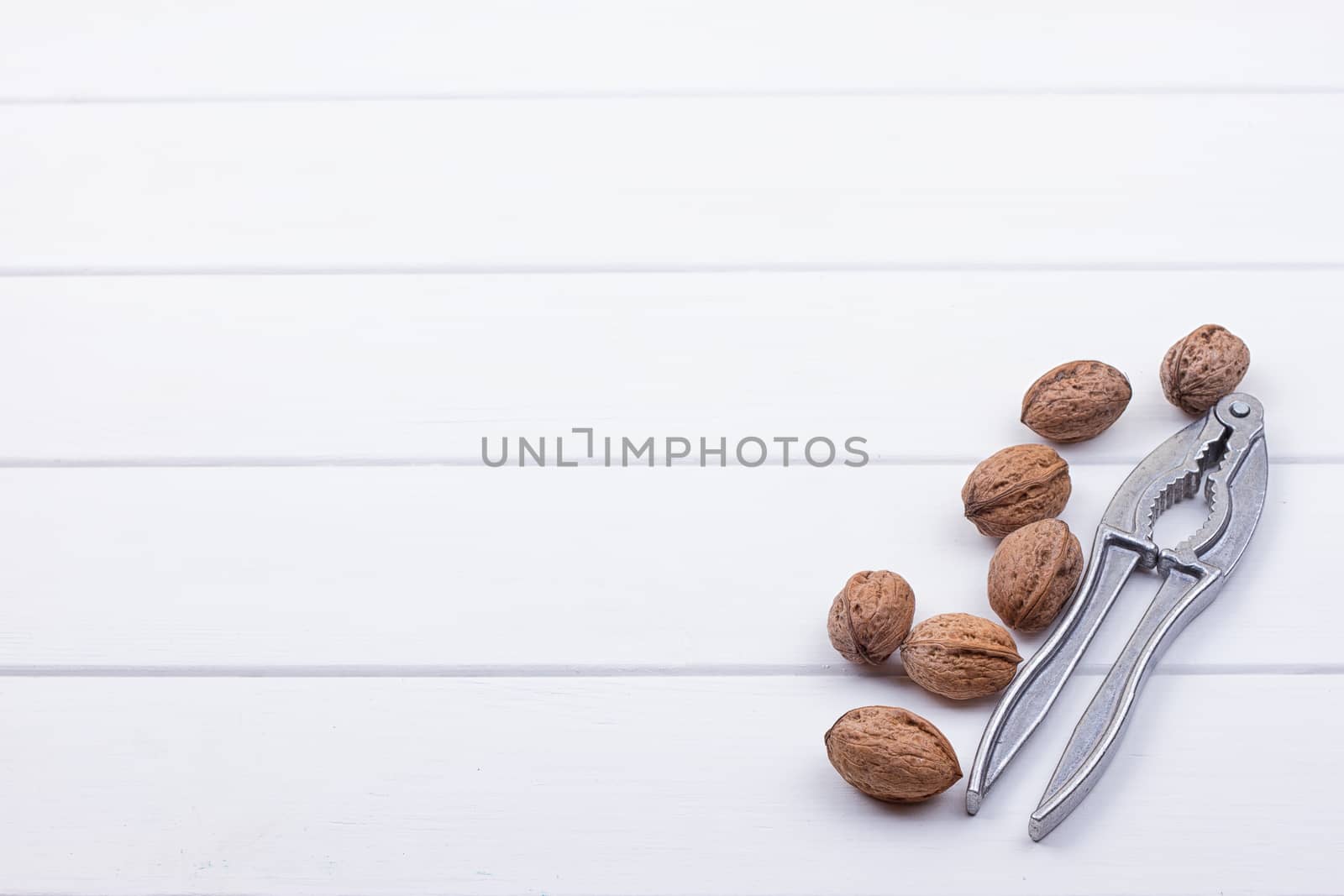 many walnuts on the white wooden background with copy-space