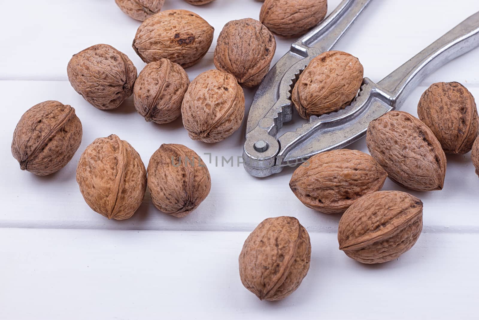 many walnuts on the white wooden background with copy-space