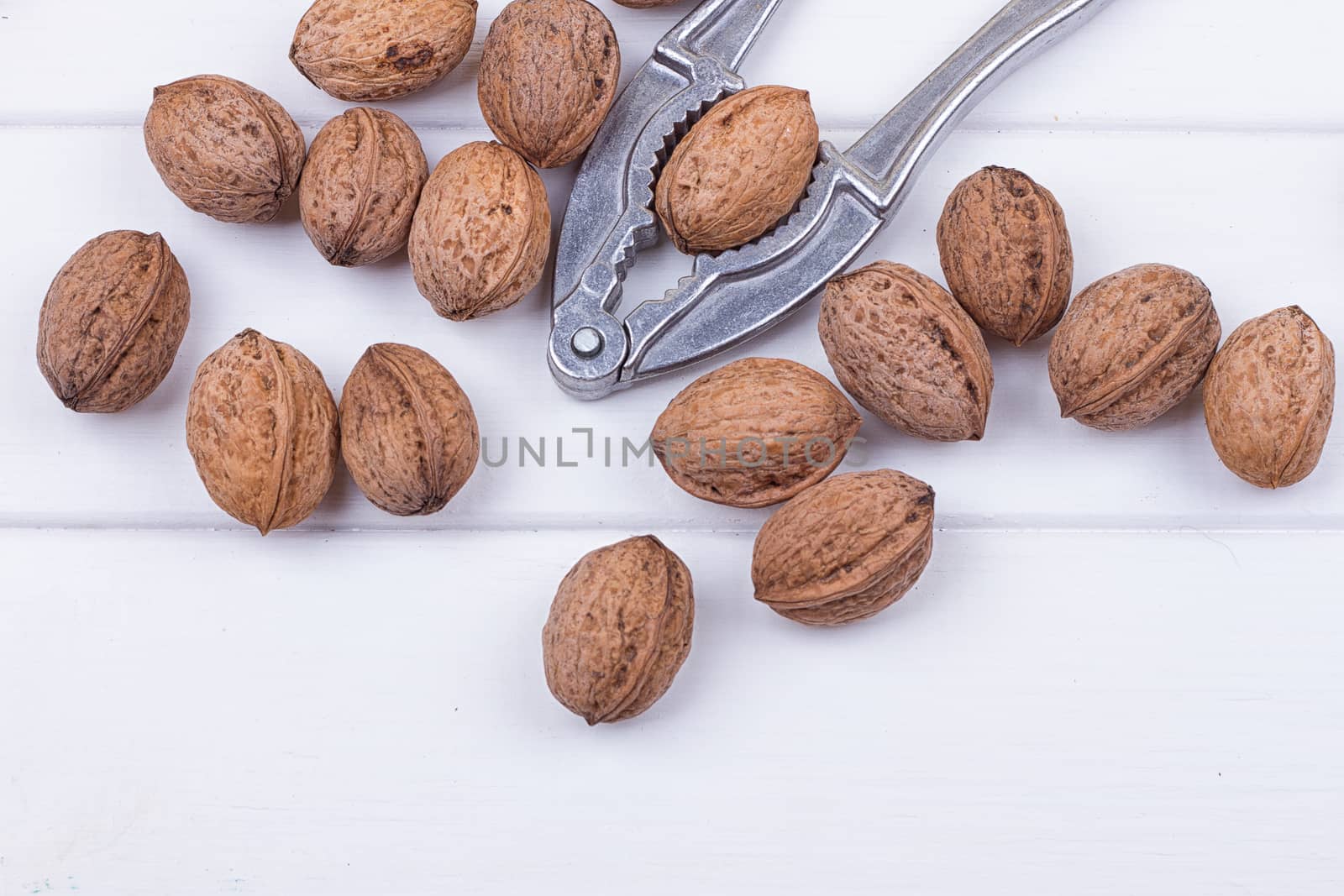 many walnuts on the white wooden background with copy-space