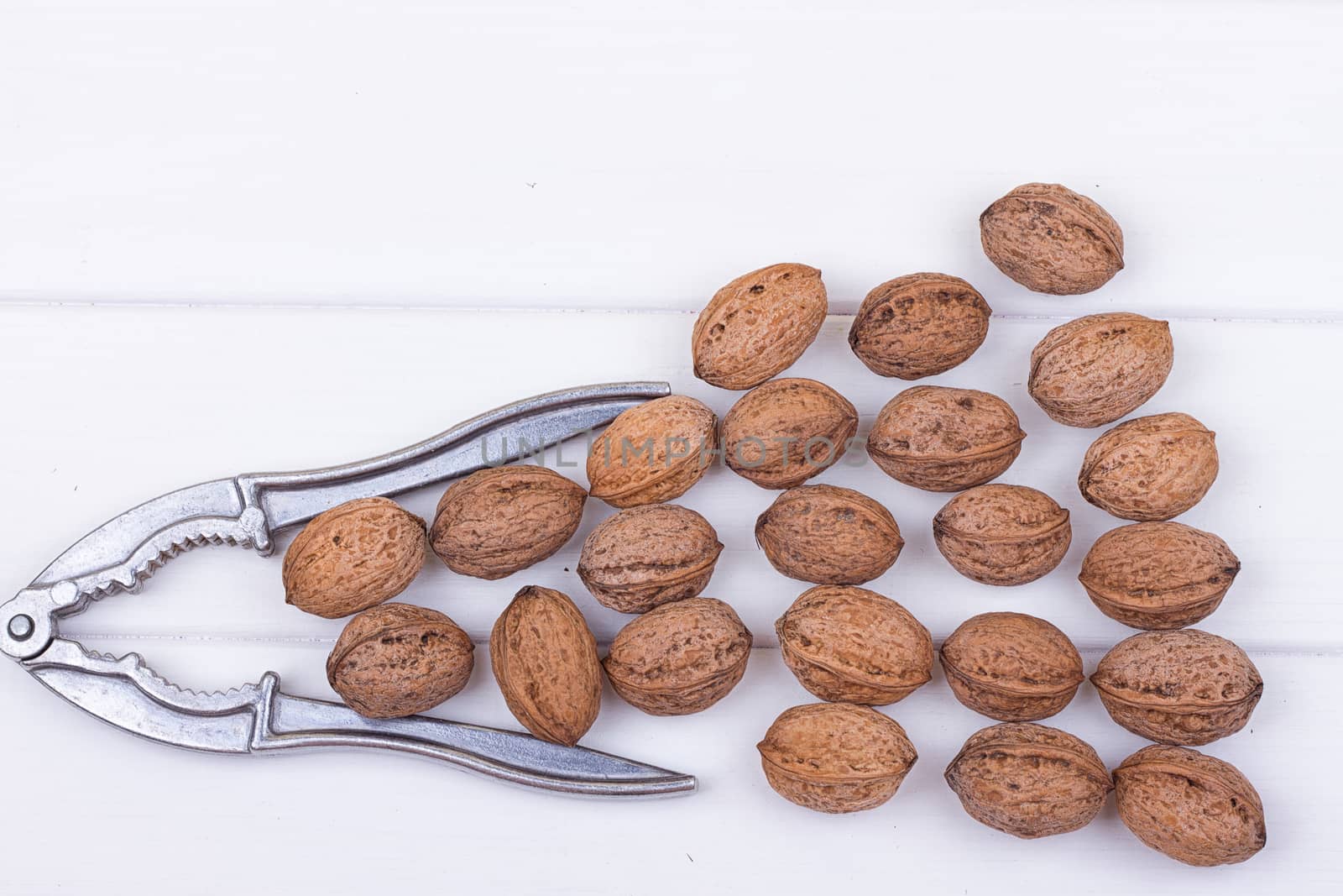 many walnuts on the white wooden background with copy-space