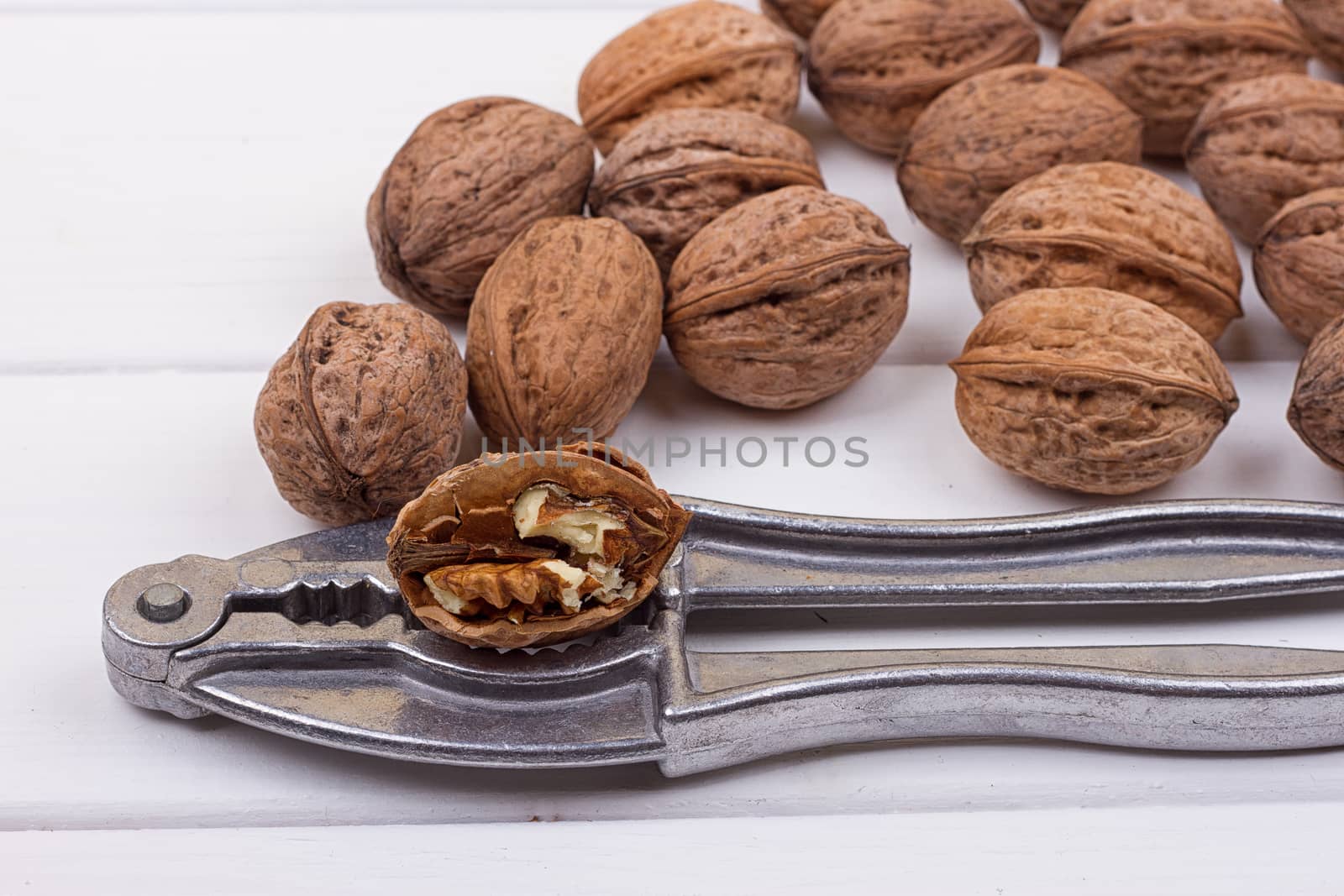 many walnuts on the white wooden background with copy-space