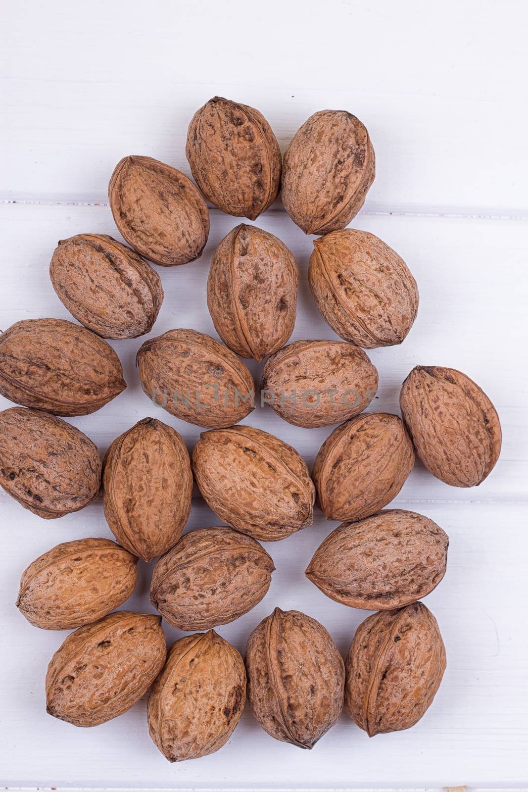 many walnuts on the white wooden background with copy-space