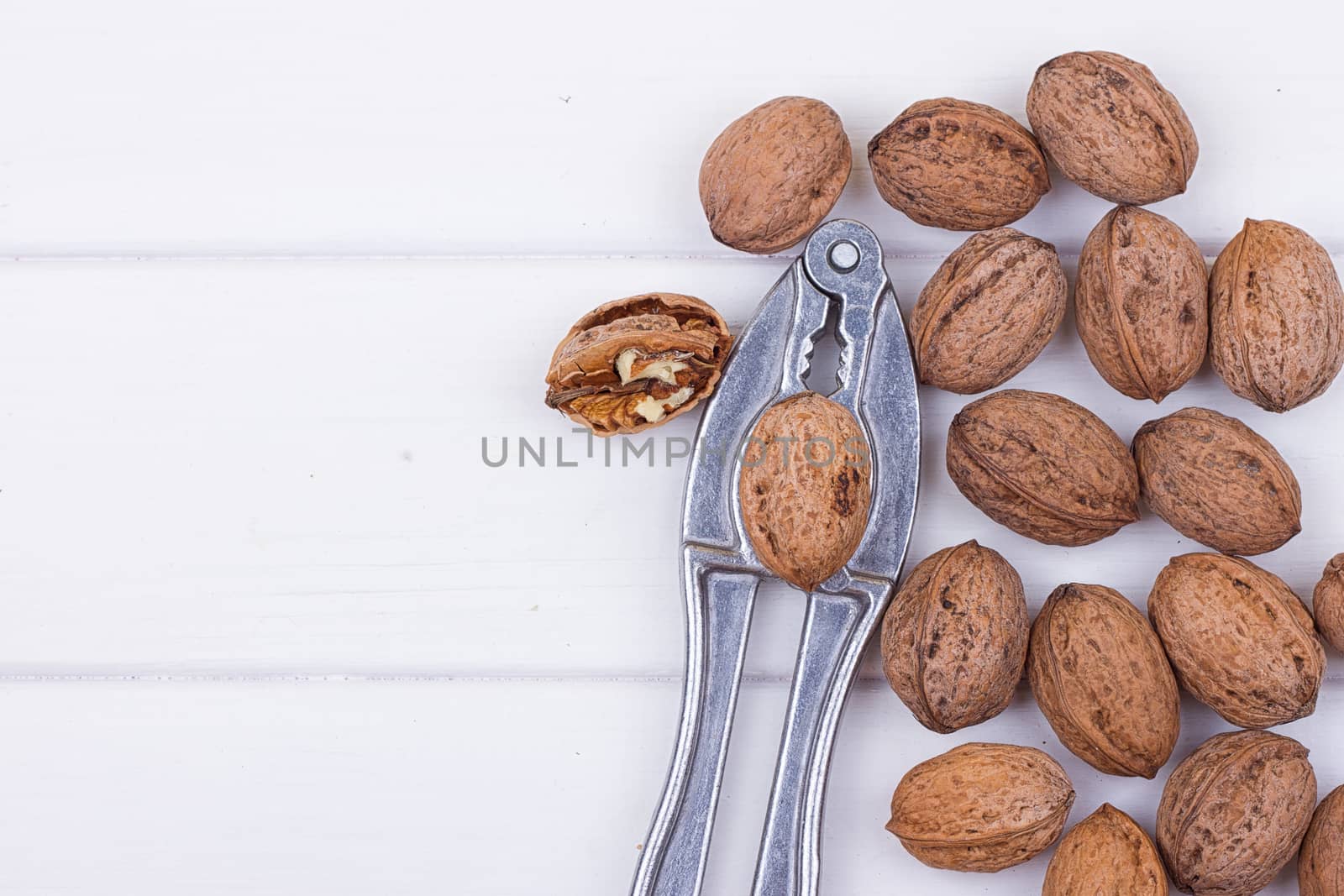 many walnuts on the white wooden background with copy-space