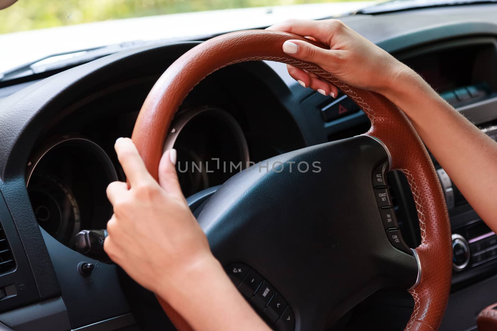 Woman's hands on a steering wheel of a car