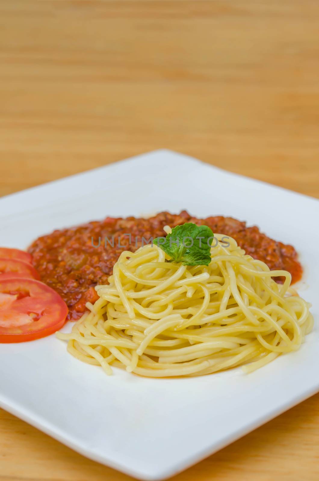 Spaghetti Bolognese meal with basil leaves and tomatoes