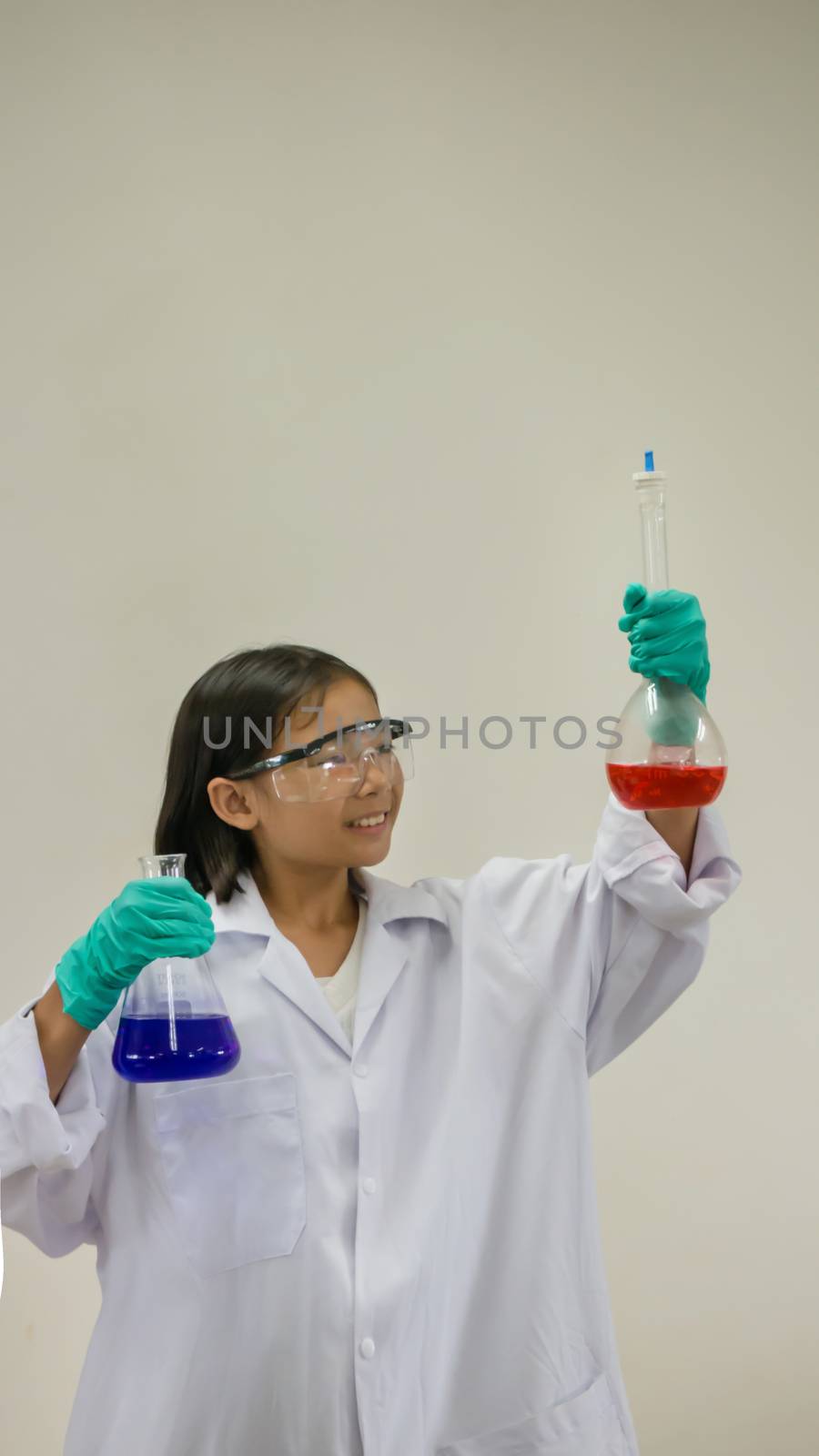 Asian little girl holding test tube or laboratory flask . Education concept.