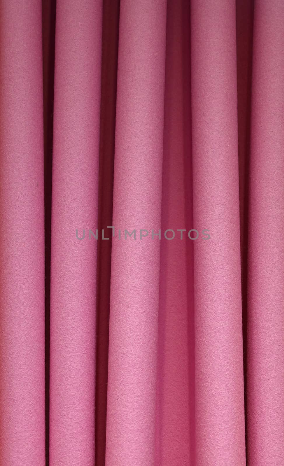 Heavy purple pink pleated felt textile curtain background with portiere drape folds, side view close up