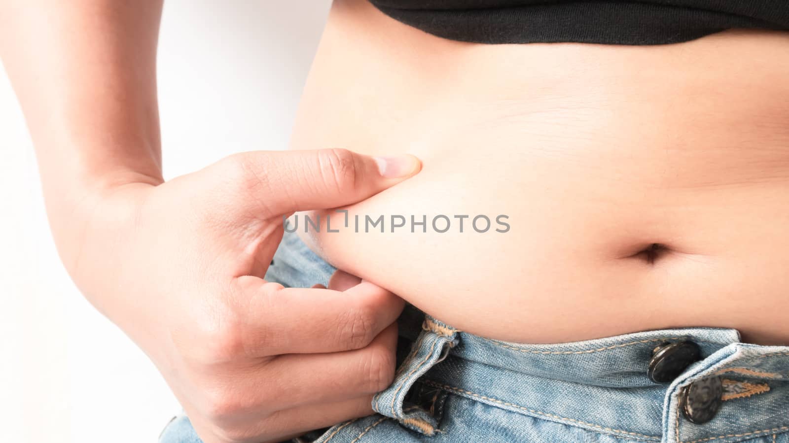 Closeup hand holding abdominal surface woman fat, healthy care and beauty concept