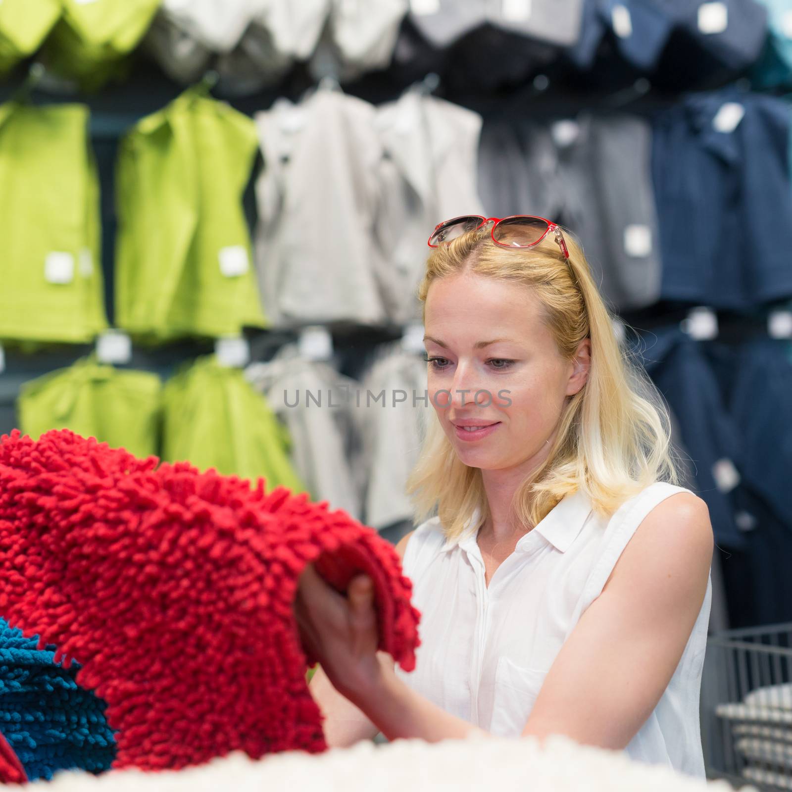 Pretty, young woman choosing the right item for her apartment in a modern home decor furnishings store.