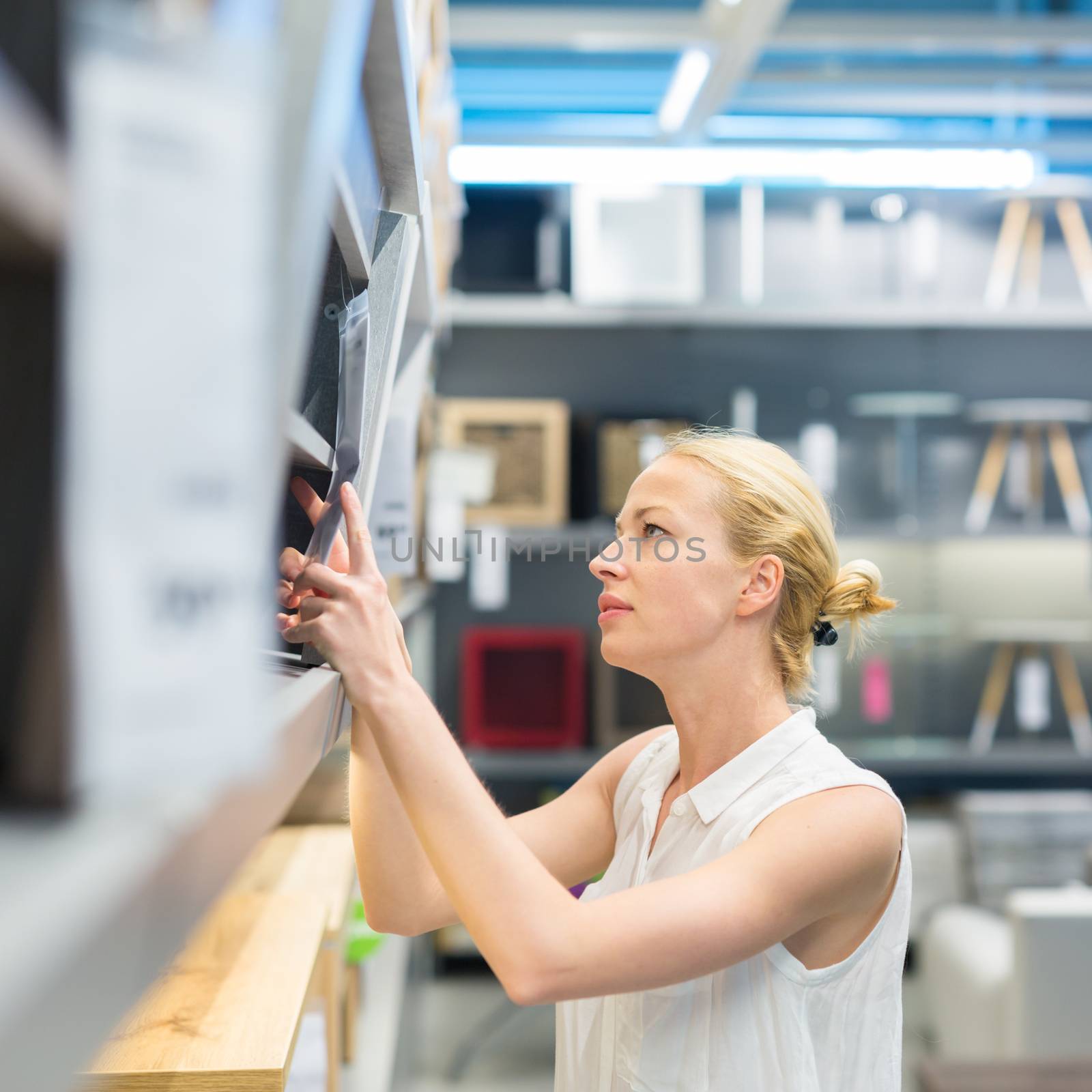 Caucasian woman shopping for furniture, recliner and home decor in store.