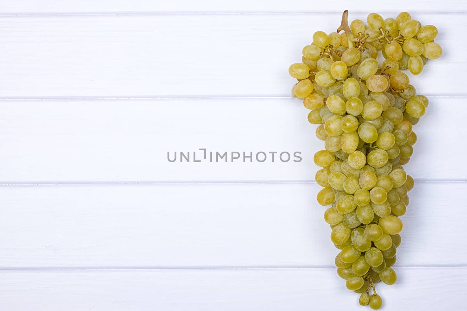 White grapes on white wooden surface by victosha