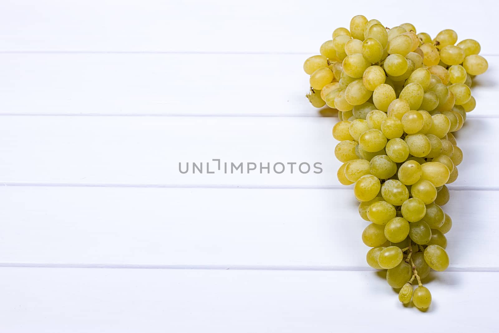 White grapes on white wooden surface. top view. copy-space