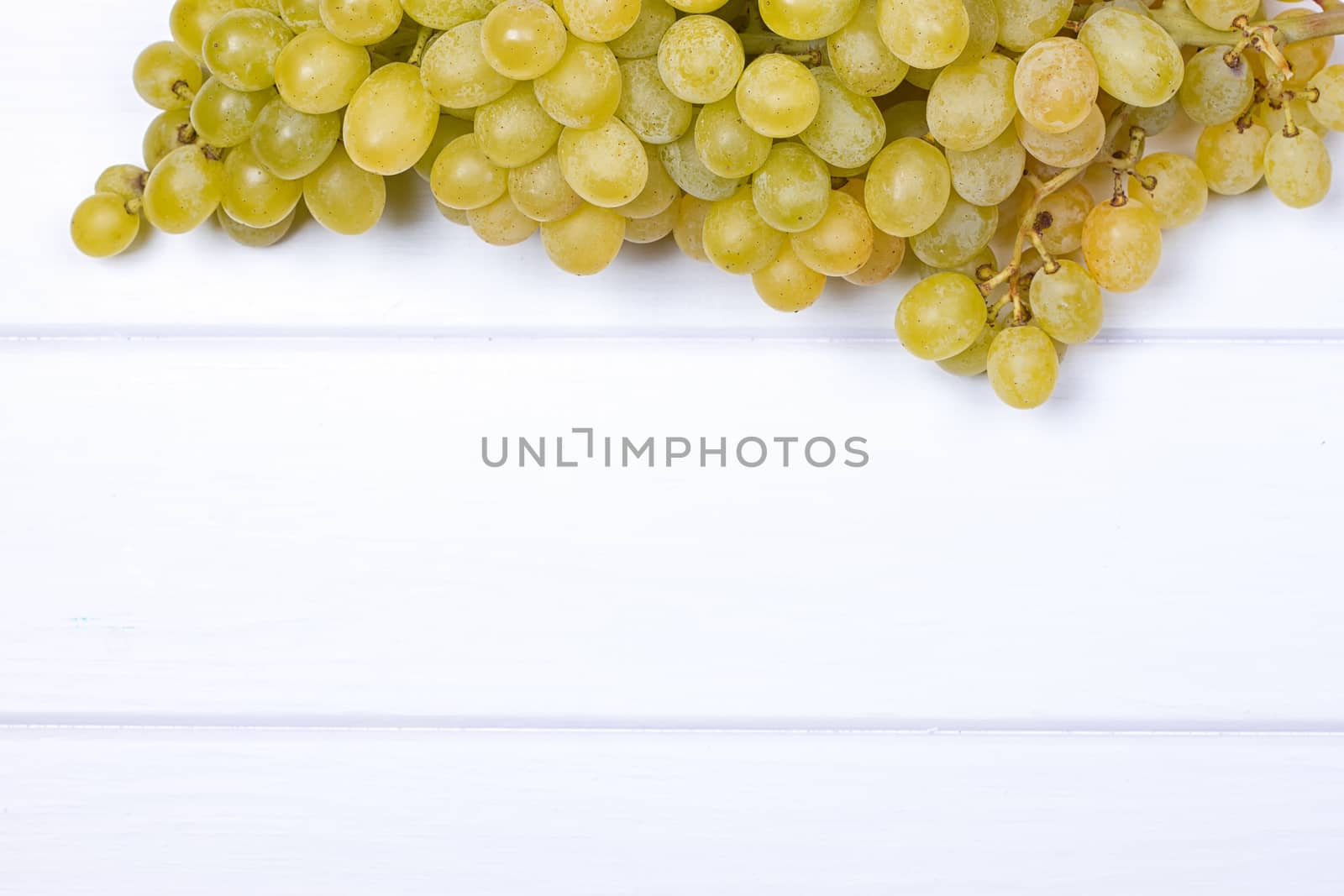 White grapes on white wooden surface. top view. copy-space