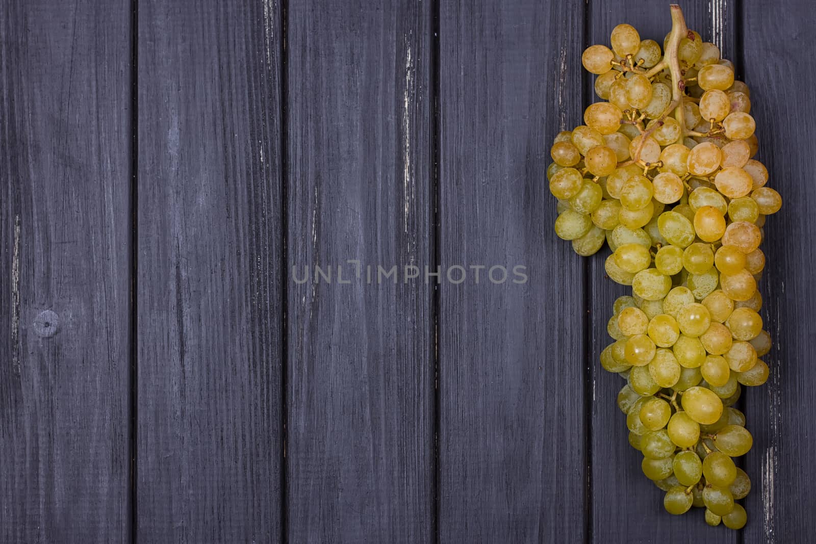 bunch of white grapes on a black wooden background. Rustic style. Place for text. copy-space