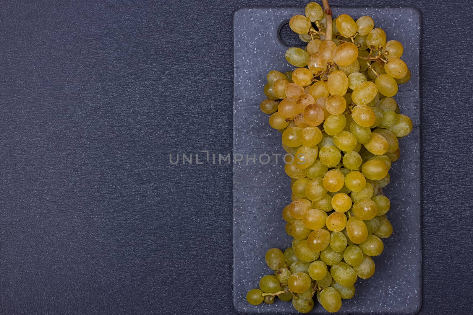 fresh delicious and healthy organic concord grapes on cutting board. copy-space