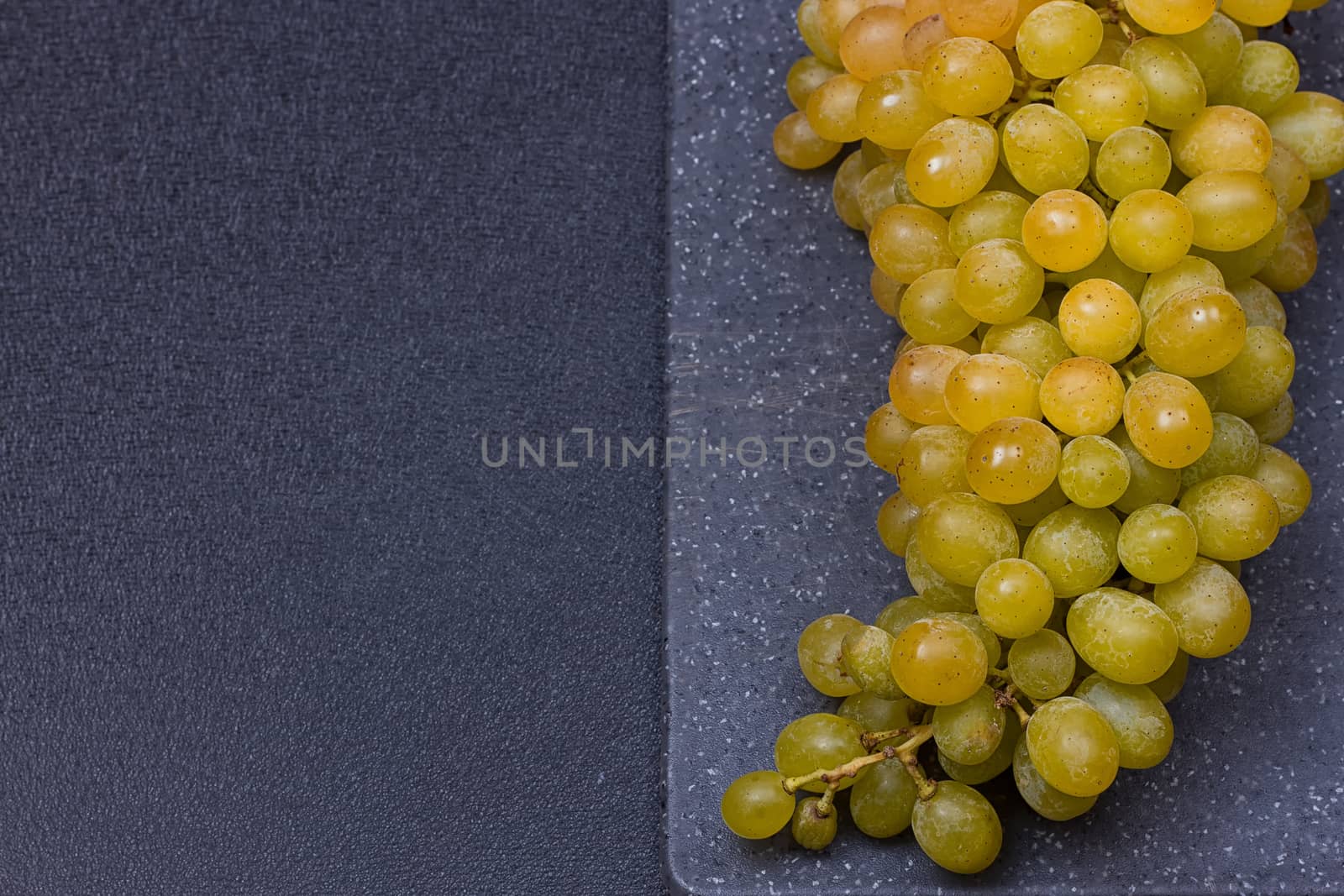 fresh delicious and healthy organic concord grapes on cutting board. copy-space