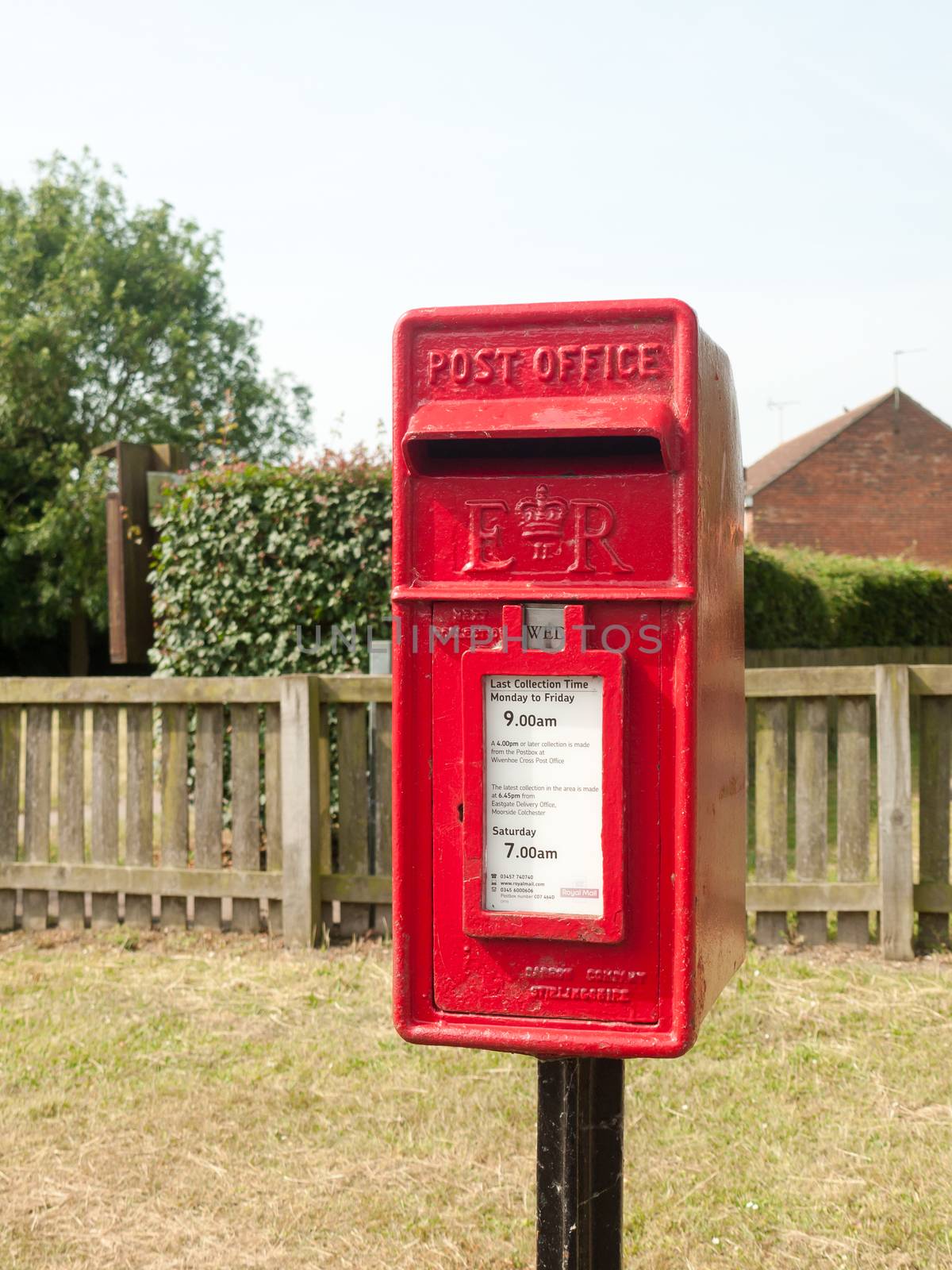 rural red royal mail box rustic outside street village; England; UK