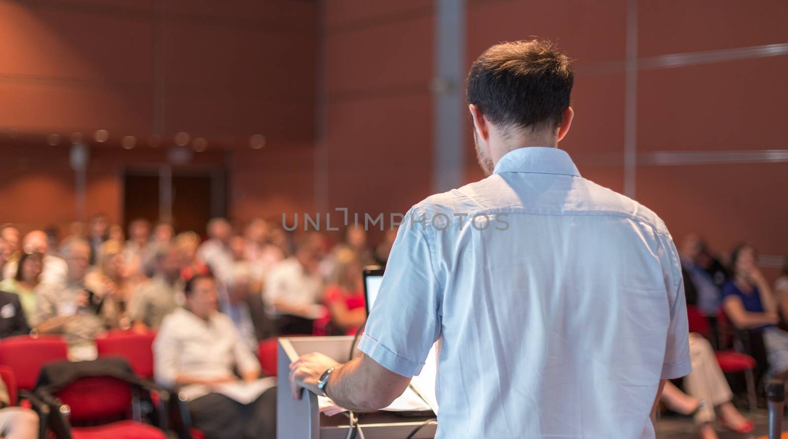Speaker at Business Conference with Public Presentations. Audience at the conference hall. Entrepreneurship club. Rear view. Horisontal composition. Background blur.