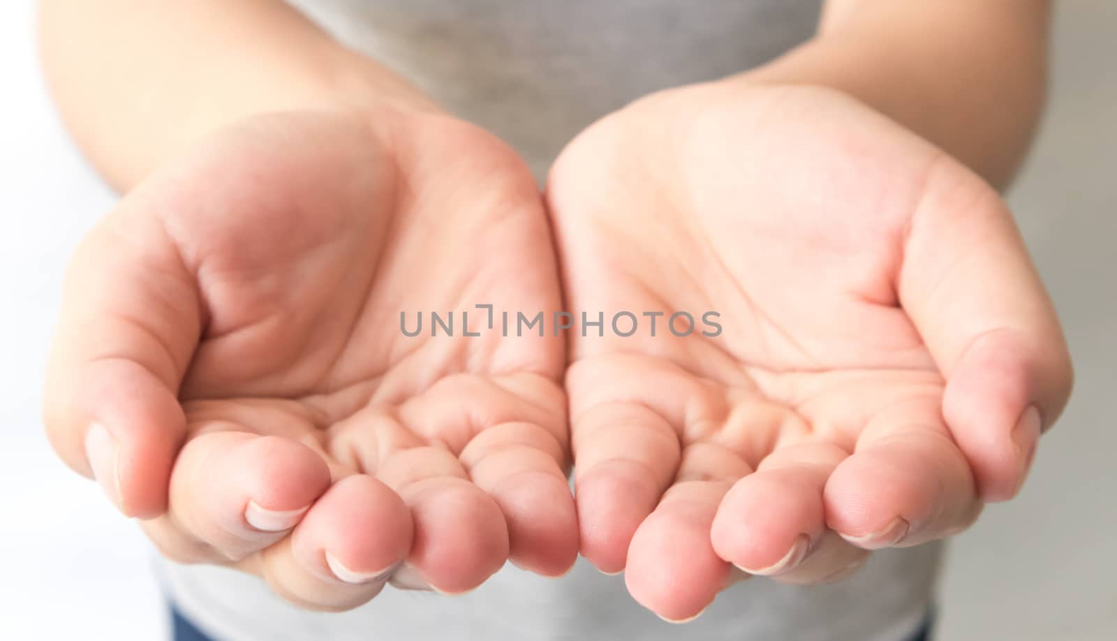 Close up outstretched cupped hands of young woman selective focus