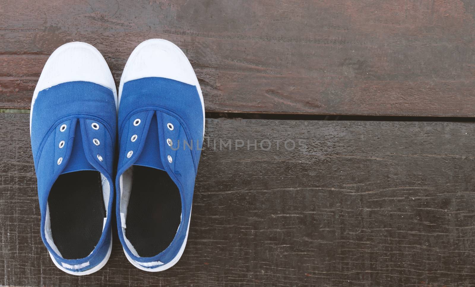 Closeup Top view blue sneaker on wood floor with vintage tone, sport or relax concept