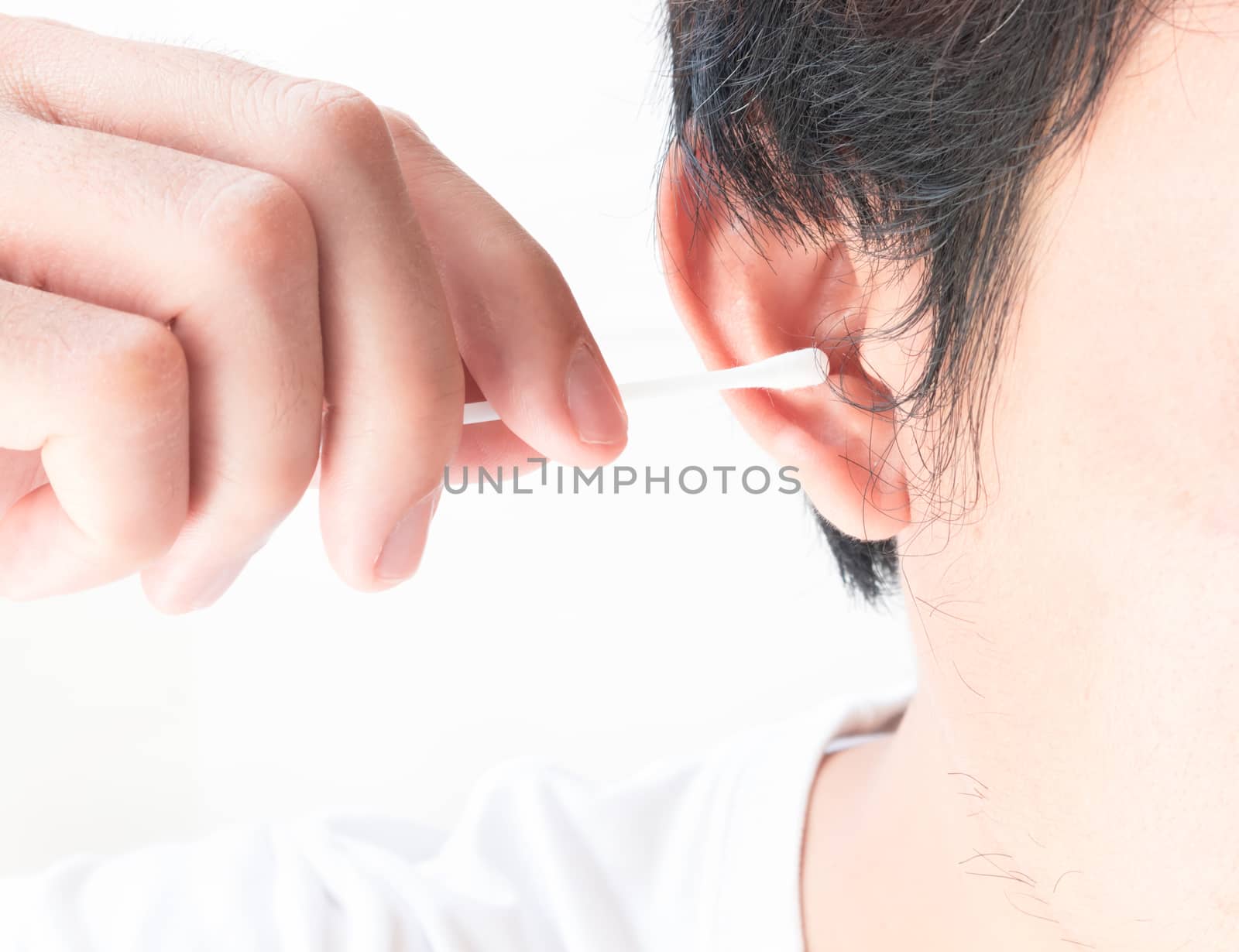 Closeup man cleaning ear with cotton bud, health care concept
