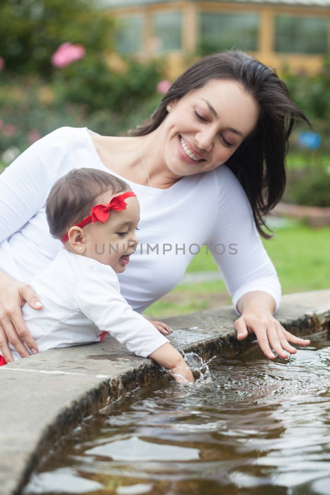 Baby girl and her mom playing with water by anamejia18