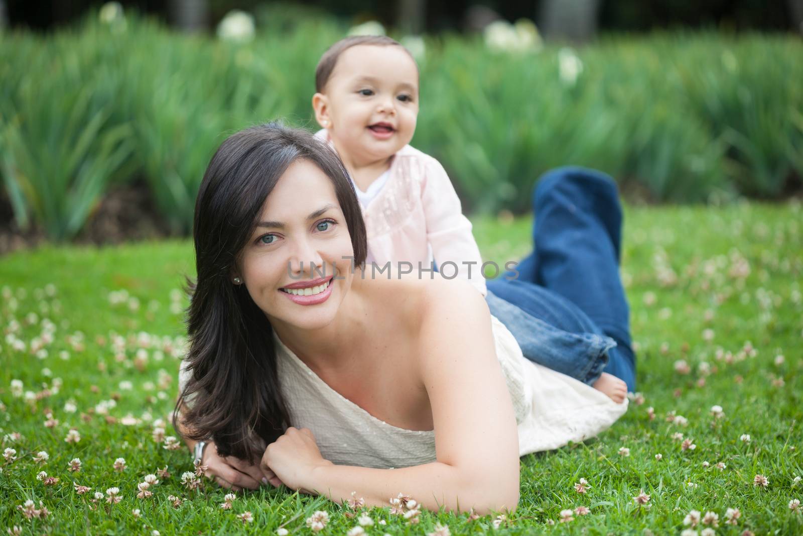 Baby girl playing with her mom on the grass