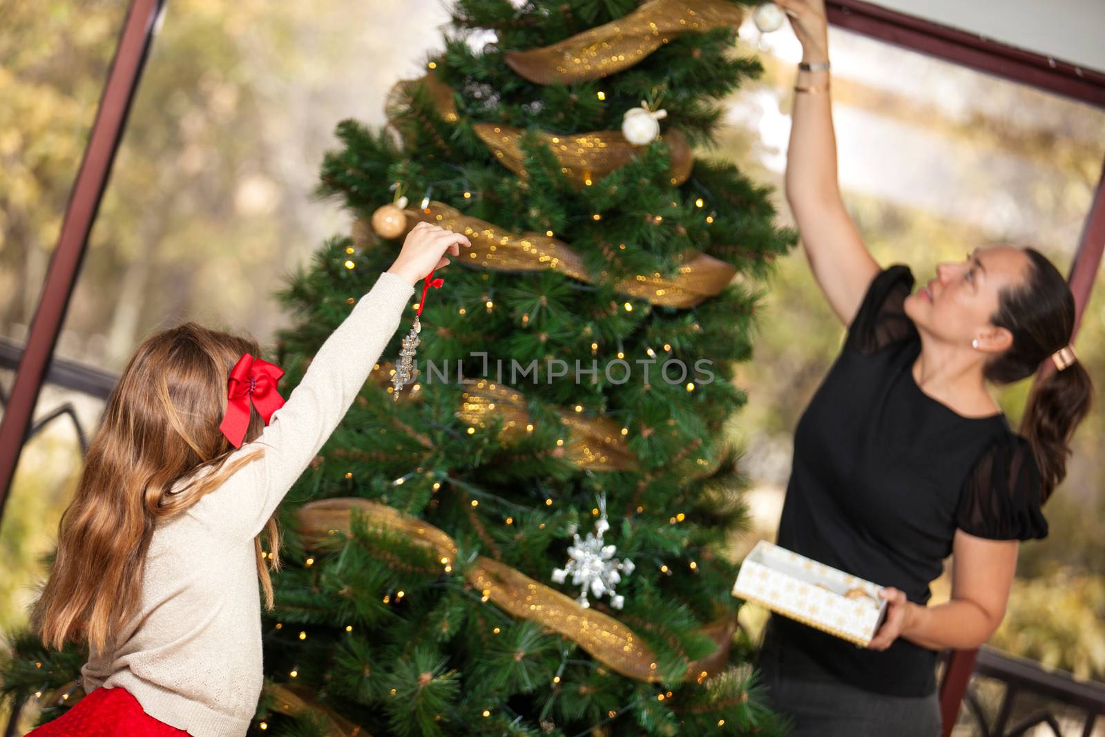 Mother and daughter decorating the Christmas tree