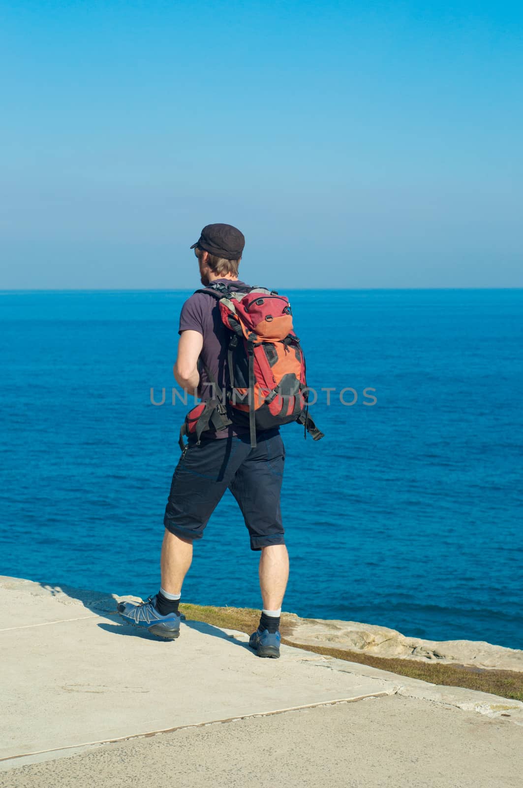 Backpacker boy traveler walk on bondi beach, Sydney, Australia.