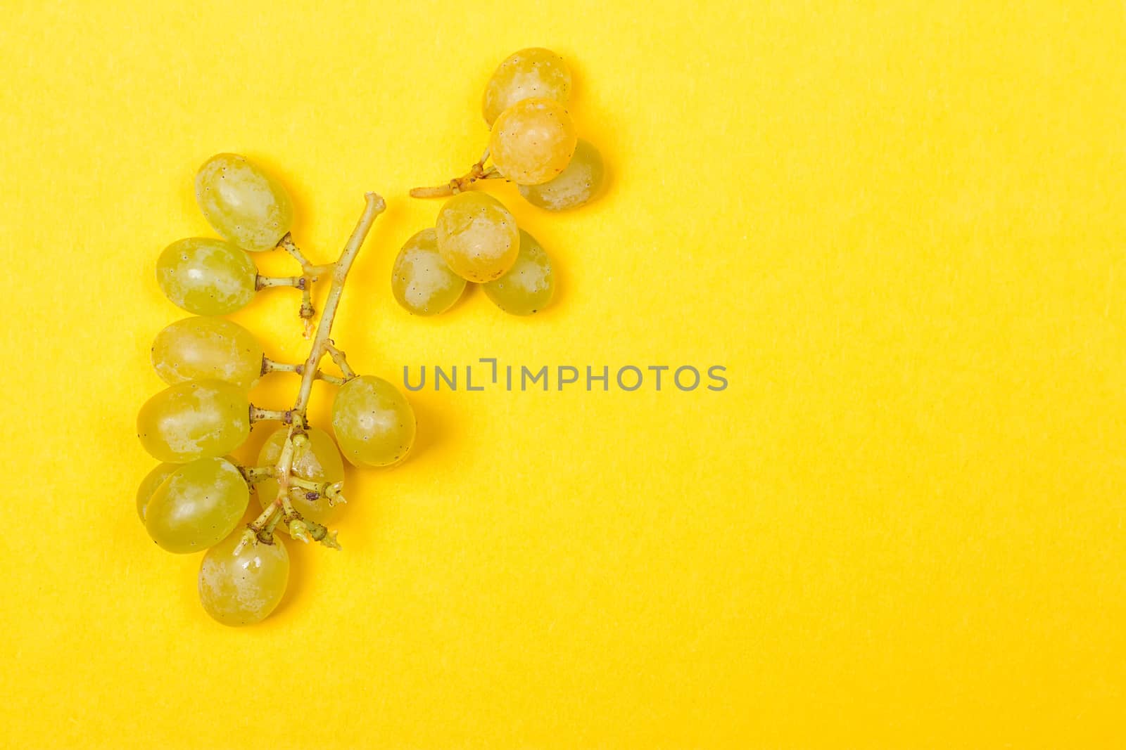 Green grape bunch on the yellow background