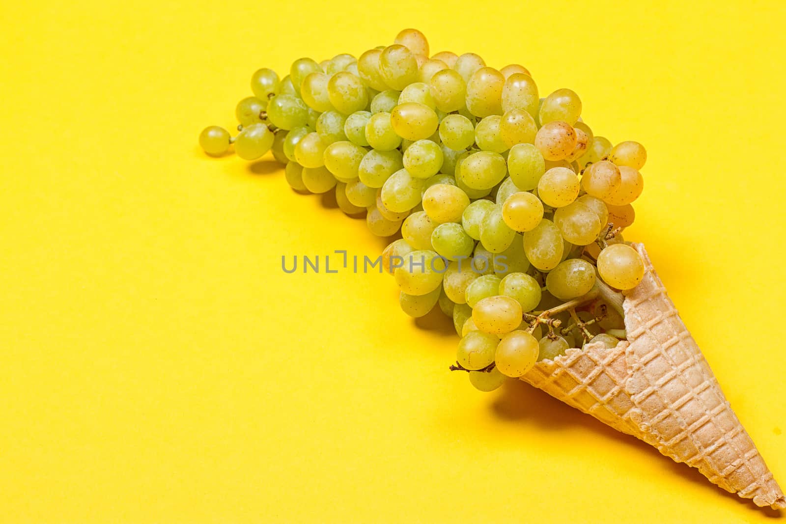 Grapes in the ice waffle on yellow background