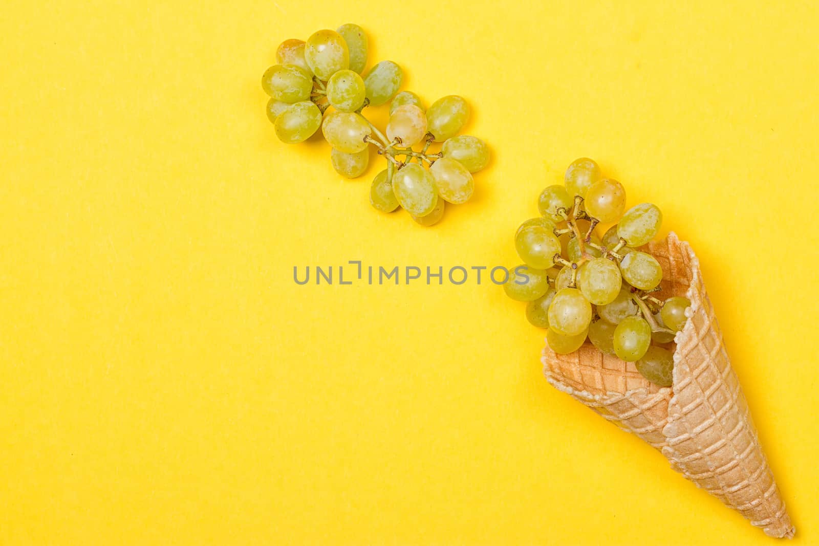 Grapes in the ice waffle on yellow background