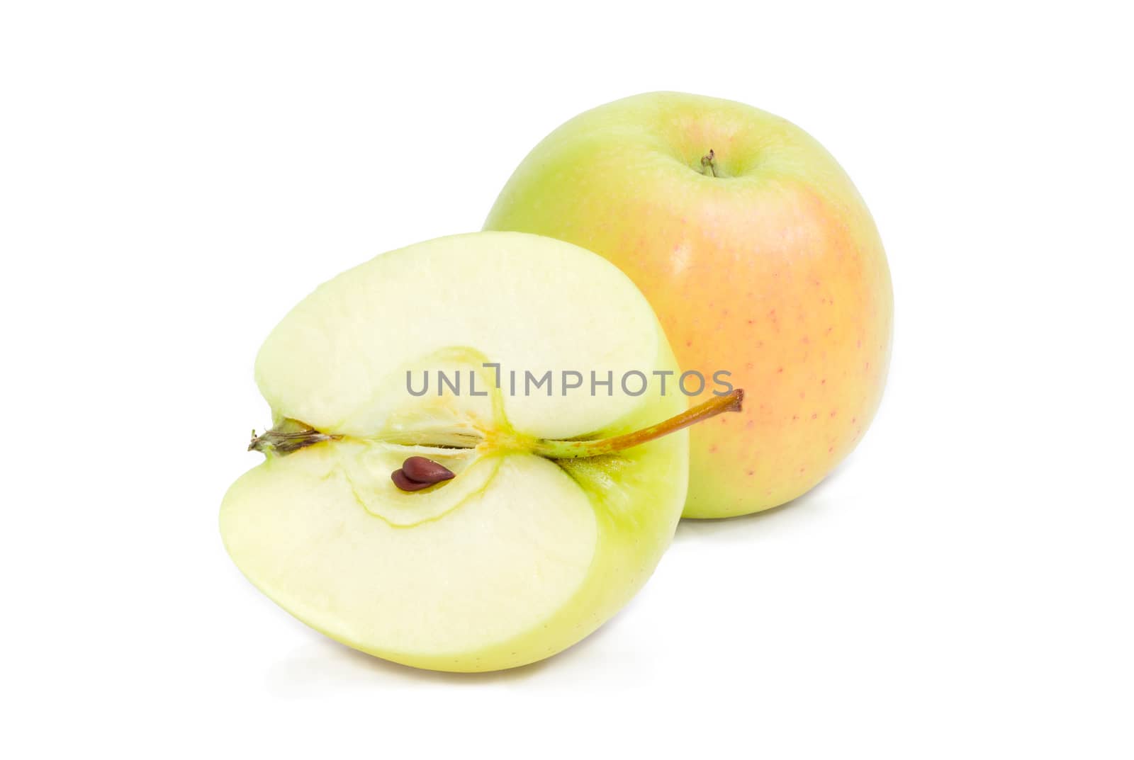 One whole and one cut in half with seeds of the green and yellow apples on a white background
