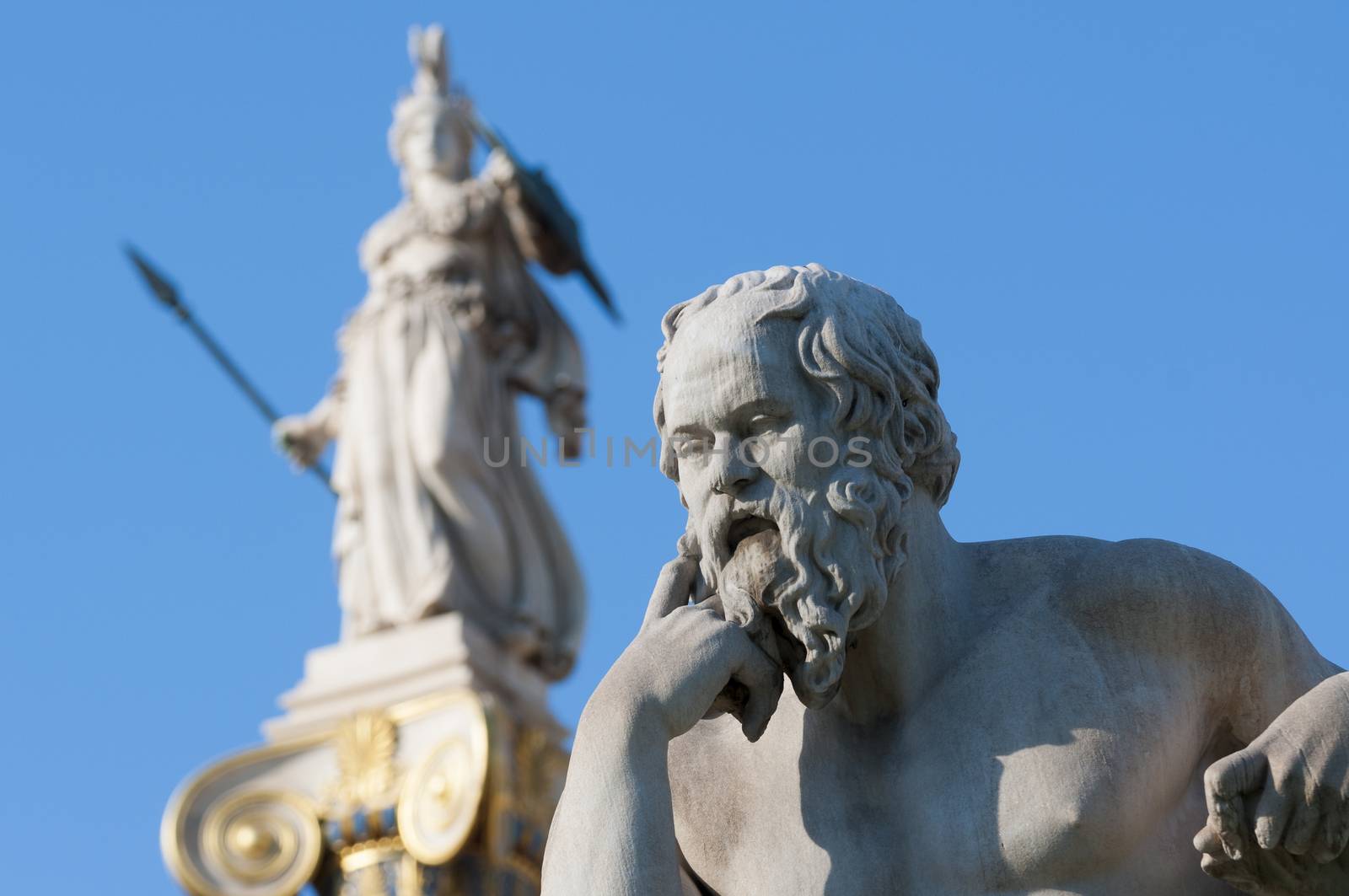 classical statue of Socrates from side with athena statue above and back